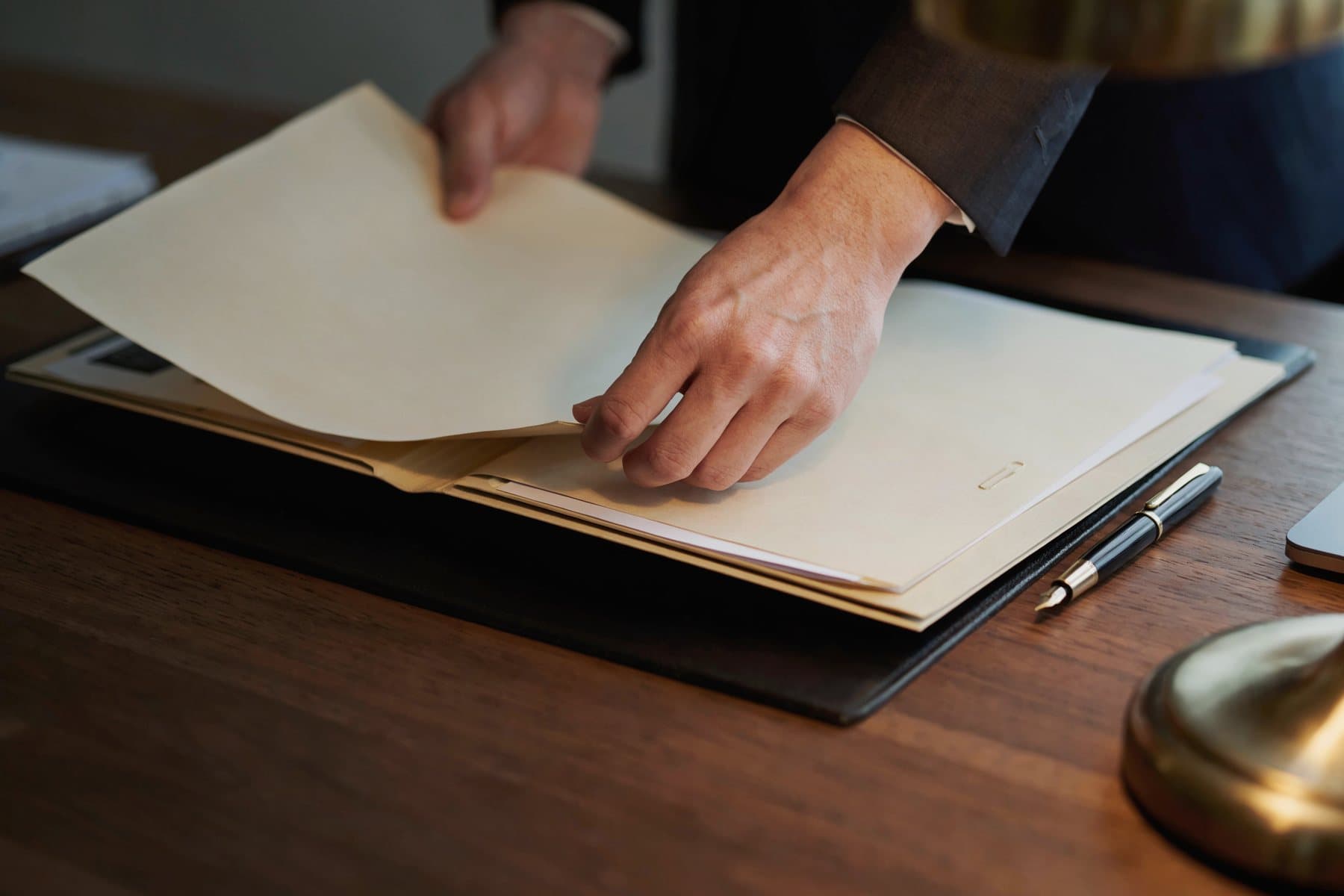 A pair of hands placing a printed sheet into a file folder.